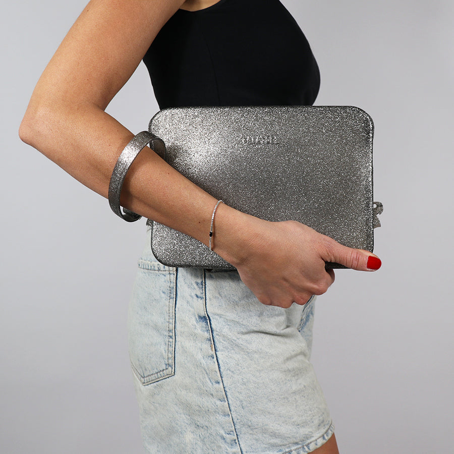 Sac Clutch Cacatoès Gisela en glitter noir, élégant et scintillant, parfait pour soirées et événements spéciaux, porté par femme.