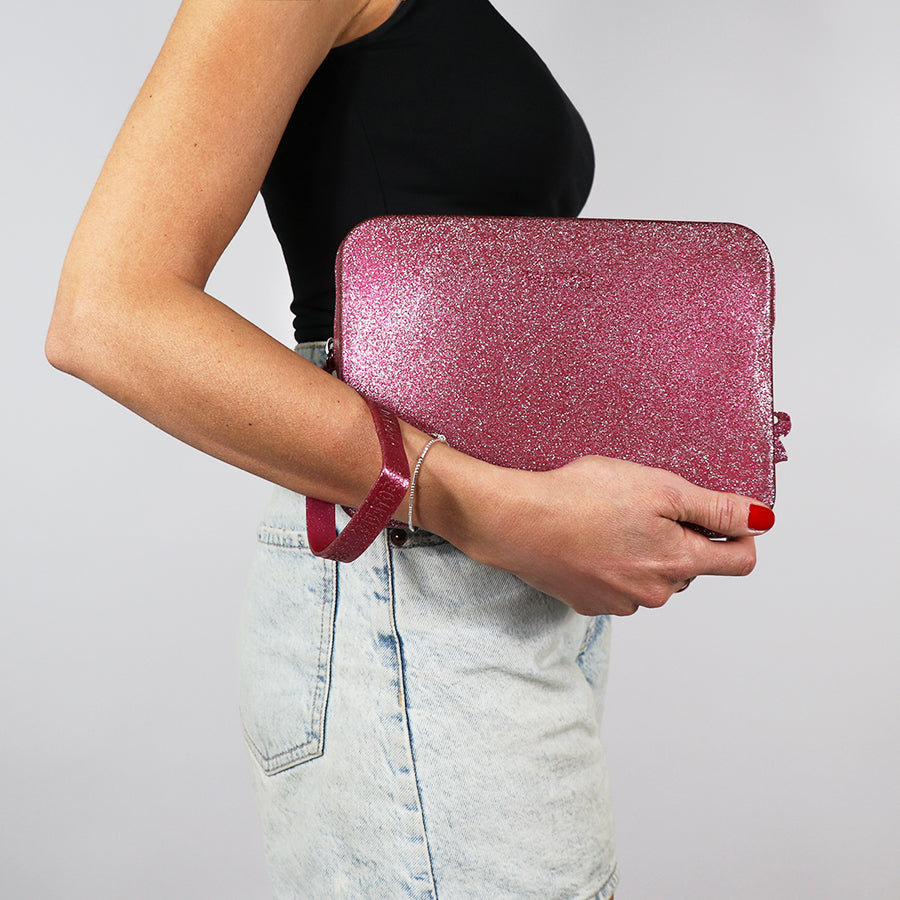 Sac Clutch Cacatoès Gisela en glitter framboise, vibrant et scintillant, parfait pour soirées et événements spéciaux, porté par femme.