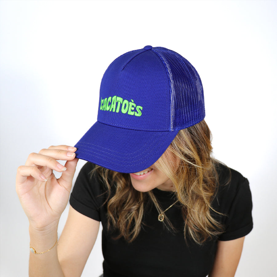 Casquette Cacottes modèle Capoeira Brasilia Royal Blue Green Fluo portée par femme : un design vibrant alliant bleu royal et accents verts fluo, parfait pour un look estival audacieux et sportif.