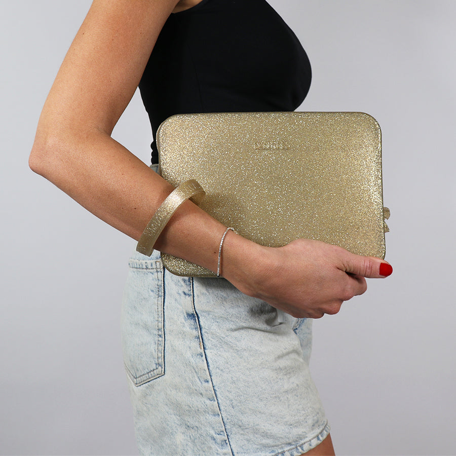 Sac Clutch Cacatoès Gisela en glitter or, élégant et scintillant, parfait pour soirées et événements spéciaux, porté par femme.